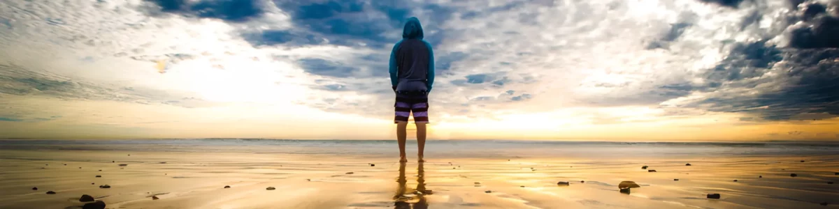 Ma malle d'enfer - Transformer votre véhicule de tout les jours en van aménagé avec nos kits d'aménagement - Homme sur la plage, devant la mer qui profite de l'instant grâce a sa malle de camping Ma Malle d'Enfer, qui transforme sa voiture de tous les jours en van aménagé